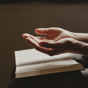 Hands of man prayer to God along with the bible, Concept of faith.